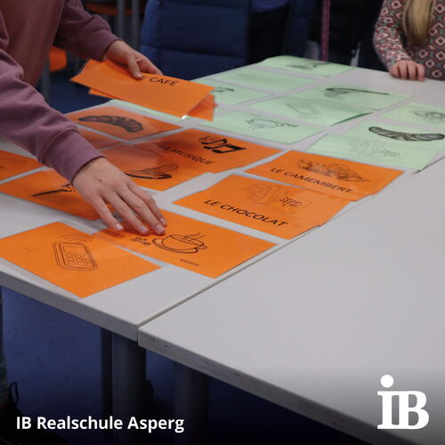 Ein Kind ordnet Karten mit französischen Begriffen auf einem Tisch während des Tags der offenen Tür an der IB Realschule Asperg.