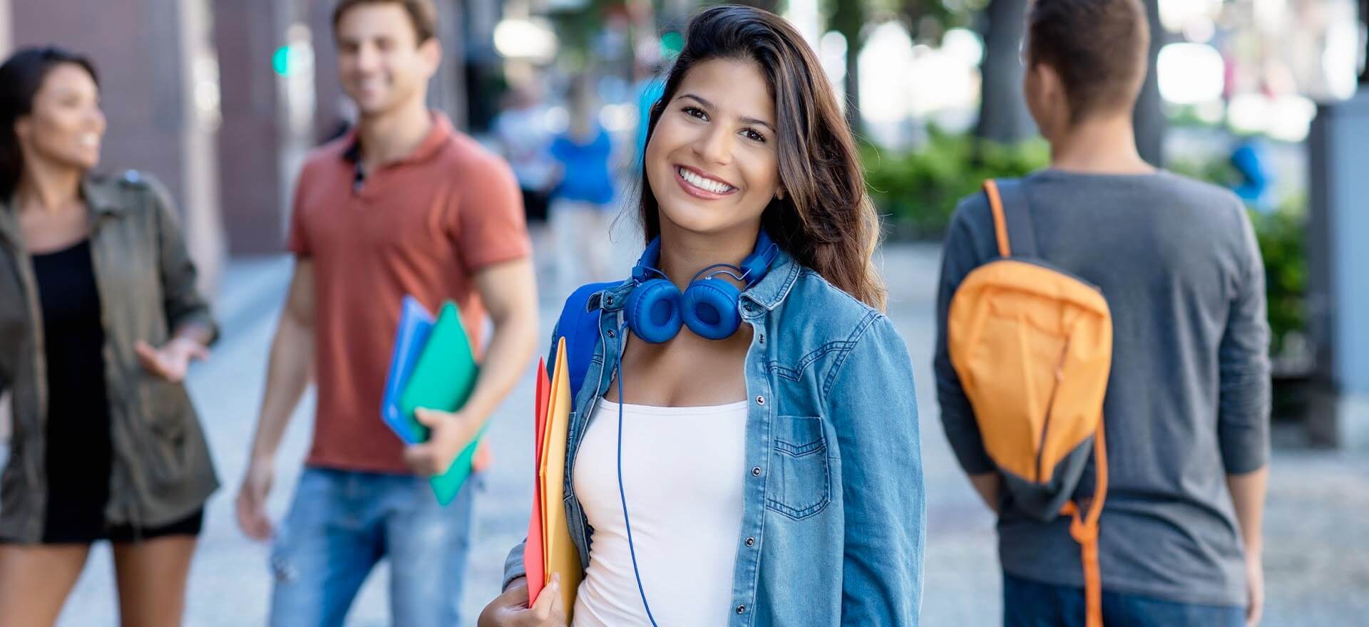 Schülerin der IB Schulen mit blauen Kopfhörern lächelt
